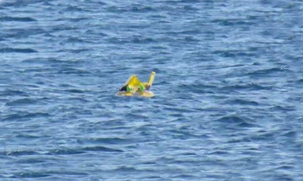 Bebê flutua no mar enquanto os pais tomam banho de sol